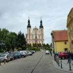 Ulica w Otmuchowie prowadząca w kierunku bazyliki z widoczną bryłą kościoła