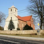 Kościół Trójcy Świętej w Starym Grodkowie, murowana świątynia z wieżą od zachodu otoczona drzewami