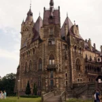 Elewacja ogrodowa zespołu pałacowego w Mosznej z zamkiem i fragmentem parku na pierwszym planie