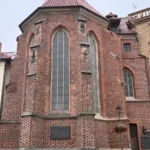 Ceglana wieża zamkowa w Brzegu z gotyckimi oknami i czerwonym dachem, fragment murów Zamku Piastów Śląskich