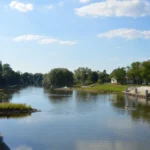 Marina w Brzegu widziana z Mostu Piastowskiego, przystań rzeczna nad Odrą z małymi wyspami i zielenią w słoneczny dzień