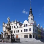 Ratusz miejski w Głubczycach z kolumną maryjną. Ujęcie z błękitnym niebem, widok na Rynek.