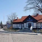 Budynek stacji kolejowej Głuchołazy Miasto z peronem i torami kolejowymi