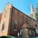 Gotycki kościół św. Michała Archanioła w Grodkowie, ceglana bazylika z wysoką wieżą i kaplicami przy nawie bocznej