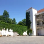 Arkadowy dziedziniec Zamku Piastów Śląskich w Brzegu z charakterystyczną wieżą, białymi murami i zielenią