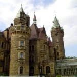 Zamek w Mosznej widziany od strony parku, z wysoką wieżą i rozbudowanym skrzydłem pałacu