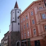 Brama Dolna w Prudniku z kamienną wieżą obronną wkomponowaną w zabudowę miejską