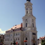 Ratusz w Prudniku z wysoką wieżą, widziany z poziomu rynku