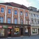 Kamienica przy Rynku 2 w Prudniku, odrestaurowany budynek z dekoracyjną fasadą i lokalami usługowymi w parterze