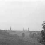 Czarno-biała panorama Prudnika z przedpolami i sylwetą miasta na horyzoncie widoczną w kierunku północnym