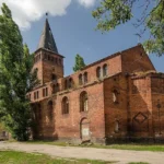 Dawny kościół ewangelicki w Grodkowie z wysoką wieżą i ceglanymi murami w stylu neoromańskim