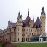 Zamek w Mosznej po remoncie elewacji w 2024 roku, widok frontu z odnowioną jasną kamienną fasadą