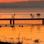 Zachód słońca nad Jeziorem Otmuchowskim z pomostem i krzesłami