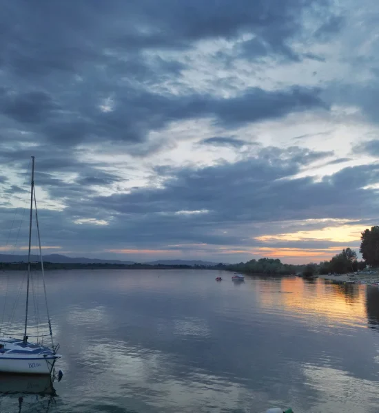 Jezioro Otmuchowskie o zachodzie słońca "Widok na Jezioro Otmuchowskie o zachodzie słońca z zielonym brzegiem i spokojną taflą wody"
